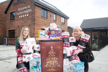 Derian House fundraiser Ellie receives the gifts from Bellway sales manager Susannah SMALLER.jpg.jpg